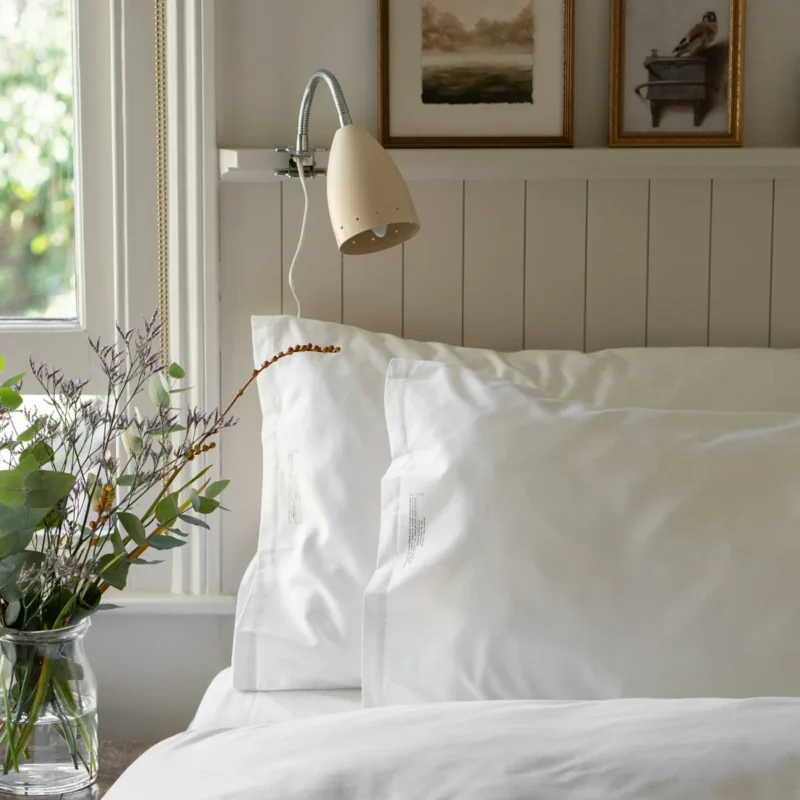 Aurelia sateen duvet cover set in ivory on a made bed with matching pillow shams