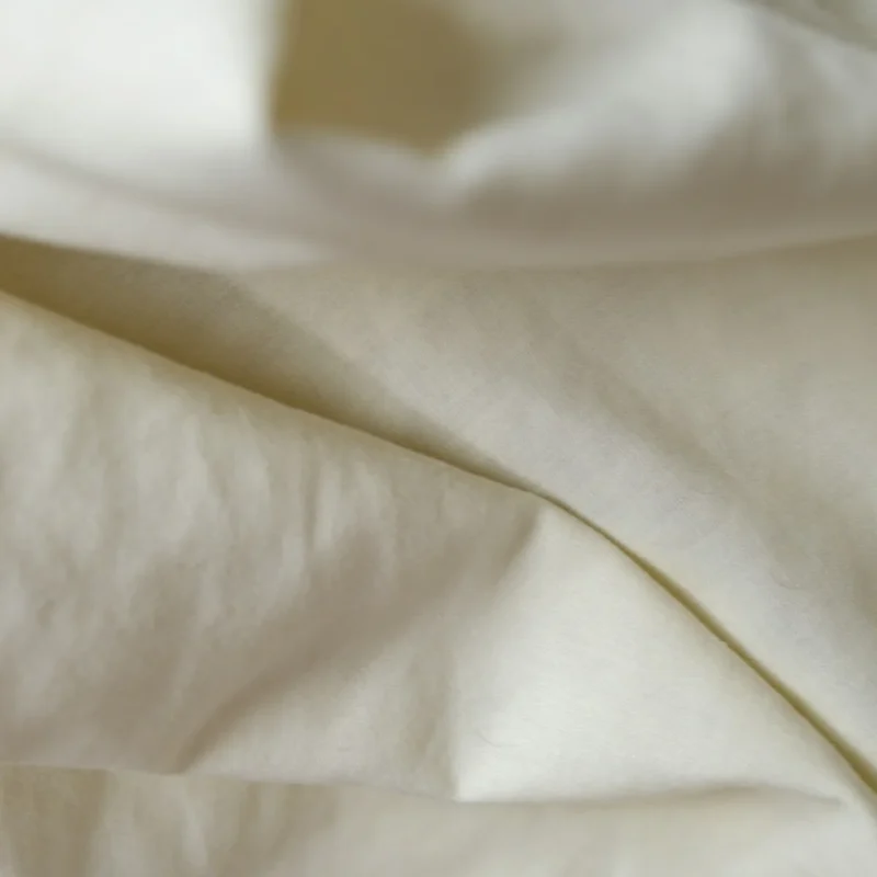Close-up of the soft lustre of ivory cotton sateen fabric