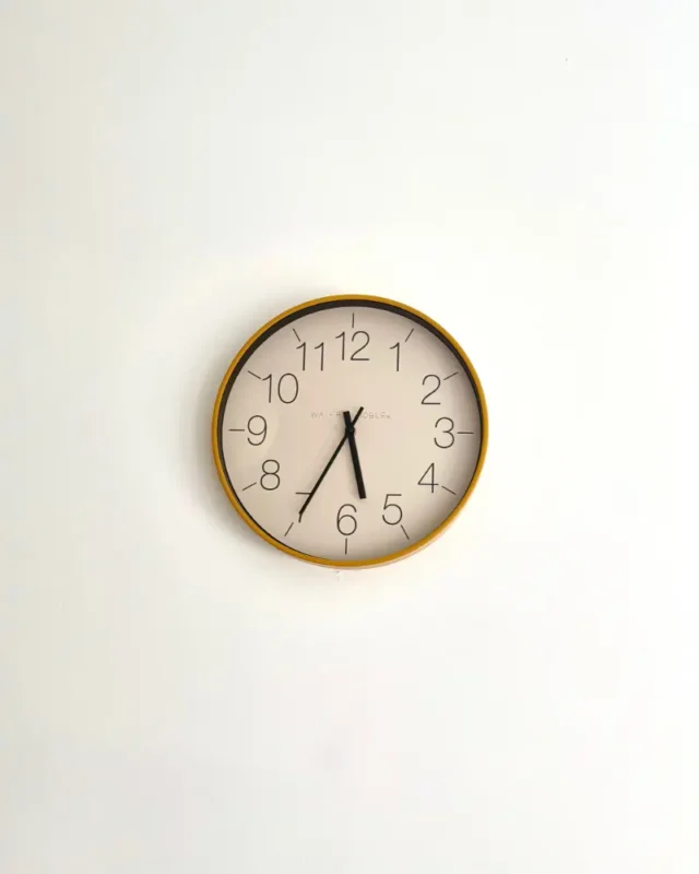 Halo minimal wall clock with a slim gold-tone rim and white dial on a clean white wall
